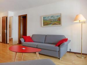 a living room with a couch and a table at Apartment Victoria A-B-C-2 by Interhome in Crans-Montana