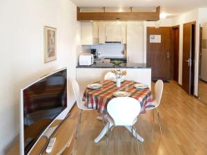a dining room with a table and chairs in a kitchen at Apartment Victoria B 7 by Interhome in Crans-Montana