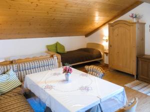 een woonkamer met een tafel en een bed bij Apartment Lassnig - ARR100 by Interhome in Arriach
