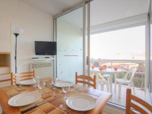 einen Esstisch mit Blick auf einen Balkon in der Unterkunft Apartment Voiles d'Or-Gênois-1 by Interhome in Le Grau-du-Roi