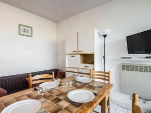ein Esszimmer mit einem Tisch und einem TV in der Unterkunft Apartment Voiles d'Or-Gênois-1 by Interhome in Le Grau-du-Roi