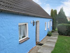 ein blaues Gebäude mit einer Tür und einem Fenster in der Unterkunft Holiday Home Am See II by Interhome in Verchen