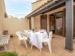 a white table and chairs on a patio at Holiday Home Les Maisons de la Plage-4 by Interhome in Le Grau-du-Roi