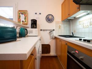 a small kitchen with a sink and a microwave at Holiday Home Les Maisons de la Plage-4 by Interhome in Le Grau-du-Roi