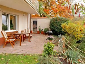 a patio with a table and chairs next to a house at Apartment Am Weinberg by Interhome in Bad Dürkheim