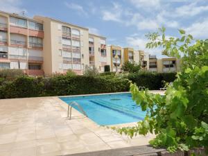 a swimming pool in front of a building at Apartment Terrasses de la Baronnie-3 by Interhome in Le Grau-du-Roi
