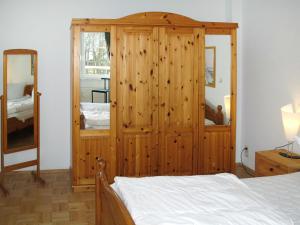 ツィノヴィッツにあるApartment Haus am Wald by Interhomeのベッドルーム(木製キャビネット、ベッド付)