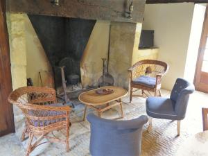 Una sala de estar con sillas y chimenea. en Holiday Home Le Petit Gîte by Interhome, en Jayac