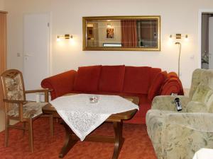 ツィノヴィッツにあるApartment Zur Düne I by Interhomeのリビングルーム(赤いソファ、テーブル付)