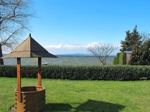 a wooden gazebo with a roof on a grass field at Apartment Seeblick by Interhome in Verchen