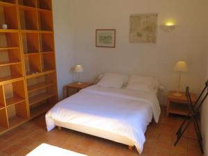 a bedroom with a bed with white sheets and two lamps at Holiday Home Bouvignou - PDG301 by Interhome in Penne-dʼAgenais