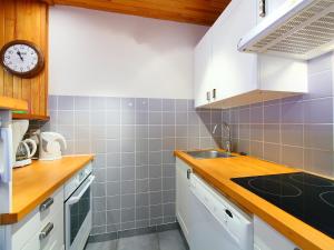 Apartment Le 2100 A et B - Lavachet-9 by Interhome في تينيِ: مطبخ مع حوض وساعة على الحائط