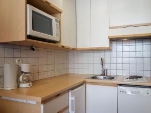 eine Küche mit einer Spüle und einer Mikrowelle in der Unterkunft Studio Le 2100 A et B - Lavachet-8 by Interhome in Tignes