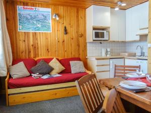 ein Wohnzimmer mit einer roten Couch in der Küche in der Unterkunft Studio Le 2100 A et B - Lavachet-8 by Interhome in Tignes