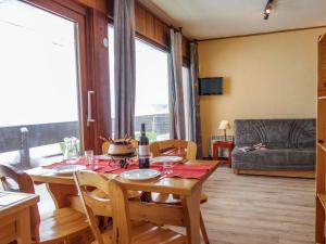 una sala da pranzo con tavolo, sedie e divano di Apartment Les Pistes-2 by Interhome a Tignes
