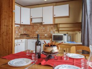 a kitchen with a table with a bottle of wine at Apartment Les Pistes - Lavachet-2 by Interhome in Tignes