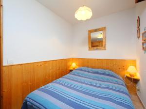シャモニー・モンブランにあるApartment L'Espace Montagne-8 by Interhomeのベッドルーム1室(ベッド1台、鏡、ランプ2つ付)
