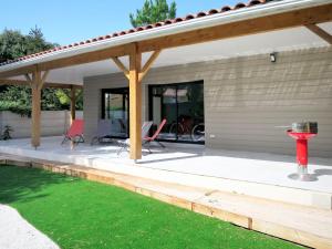 a covered patio with chairs and a table at Holiday Home Yara - LCA126 by Interhome in Lacanau
