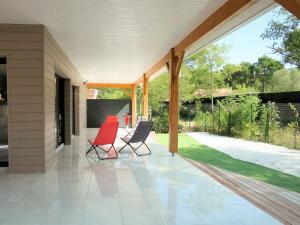 a screened porch with two chairs and a table at Holiday Home Yara - LCA126 by Interhome in Lacanau