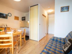 a kitchen and dining room with a table and chairs at Apartment Les Mousquetons-20 by Interhome in La Toussuire