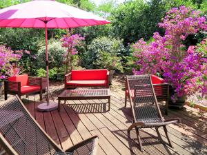 una terraza con sillas, una mesa y una sombrilla en Holiday Home Les Bains Douche - SUL180 by Interhome en Soulac-sur-Mer