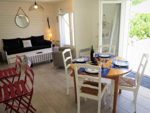 Saint-Vivien-de-MédocにあるHoliday Home Mon Poussin - SVV120 by Interhomeのダイニングルーム(テーブル、椅子、ソファ付)