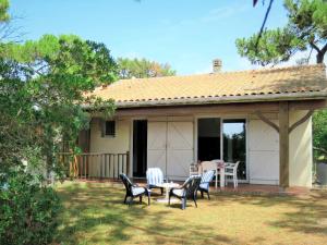 a house with chairs and a table on a yard at Holiday Home Anne Marie by Interhome in Lacanau-Océan