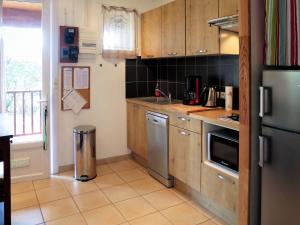 uma cozinha com armários de madeira e electrodomésticos de aço inoxidável em Holiday Home Anne Marie - LCA195 by Interhome em Lacanau-Océan