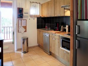 a kitchen with wooden cabinets and stainless steel appliances at Holiday Home Anne Marie by Interhome in Lacanau-Océan