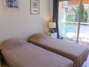 a bedroom with two beds next to a window at Apartment La Pinède-1 by Interhome in Cagnes-sur-Mer