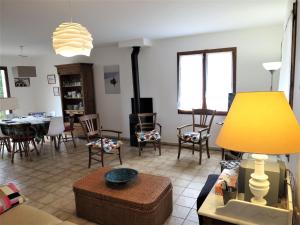ein Wohnzimmer mit Stühlen und einem Tisch mit einer gelben Lampe in der Unterkunft Holiday Home Caberal by Interhome in Soulac-sur-Mer
