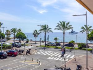 a parking lot with palm trees and a cruise ship in the ocean at Apartment La Pinède-2 by Interhome in Puits