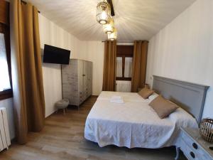 欽瓊的住宿－Casa La Plazuelilla，一间卧室配有一张床和一台电视