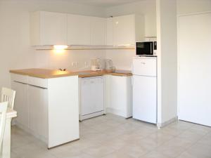 ビスカロッス・プラージュにあるHoliday Home Résidence Indigo II - BPL325 by Interhomeのキッチン(白いキャビネット、白い冷蔵庫付)