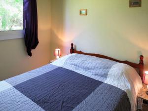 - une chambre avec un lit bleu et blanc et une fenêtre dans l'établissement Holiday Home Castagney by Interhome, à Gaillan-en-Médoc