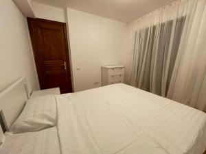 1 dormitorio con cama blanca y ventana en Mikerynos 1, en Sinaia