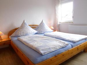ノルトダイヒにあるApartment Dehne-2 by Interhomeのベッドルーム1室(白いシーツと枕が備わる木製ベッド1台付)