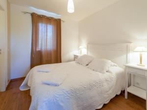 een slaapkamer met een wit bed met twee handdoeken erop bij Apartment Les Cottages du Lac T2 by Interhome in Parentis-en-Born