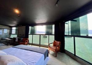 a bedroom with a bed and a view of the water at 1819 Marine Hotel in Ubatuba