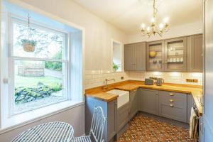 a kitchen with a sink and a window at Penninghame West Lodge in Newton Stewart
