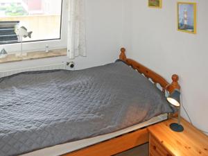 een bed met een houten frame in een slaapkamer bij Apartment Norderney by Interhome in Dornumersiel