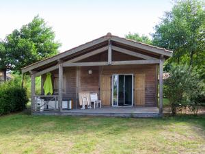 eine Hütte mit einem Tisch und Stühlen im Hof in der Unterkunft Holiday Home Les Cottages du Lac M3 by Interhome in Parentis-en-Born