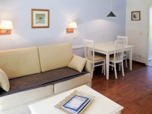 ein Wohnzimmer mit einem Sofa und einem Tisch in der Unterkunft Apartment Les Cottages du Lac T1 by Interhome in Parentis-en-Born
