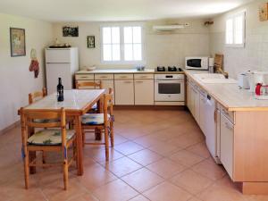 une cuisine avec une table et des chaises et une cuisine avec des appareils blancs dans l'établissement Holiday Home Cambou - AAS400 by Interhome, à Albas