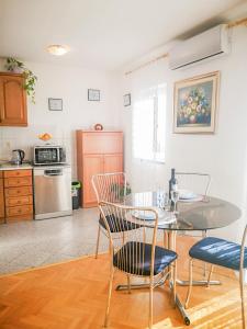 eine Küche mit einem Tisch und Stühlen im Zimmer in der Unterkunft AriaDeMar in Koromačno