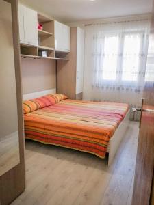 ein Schlafzimmer mit einem Bett in einem Zimmer mit einem Fenster in der Unterkunft AriaDeMar in Koromačno