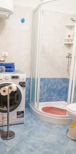 ein Bad mit einer Dusche, einer Waschmaschine und einem Trockner in der Unterkunft AriaDeMar in Koromačno