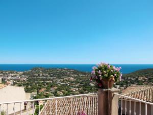 a vase of flowers on a balcony with the ocean at Holiday Home Yalou by Interhome in Cavalaire-sur-Mer