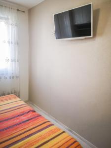 a bedroom with a flat screen tv on the wall at AriaDeMar in Koromačno