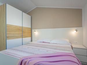 een slaapkamer met een groot bed met paarse lakens bij Holiday Home Prenc - PZN212 by Interhome in Munci